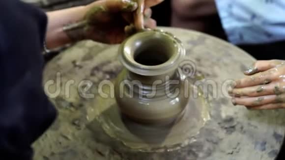 双手正在陶罐轮上制造一个罐子或花瓶视频的预览图