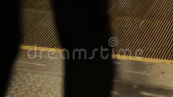 人们在地铁自动扶梯的移动画布上行走双脚穿在扶梯的台阶上特写视频的预览图