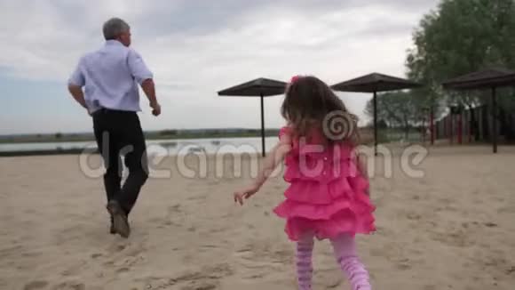 女孩和她的祖父正跑回河边那个女孩正试图抓住她的祖父4K慢慢视频的预览图