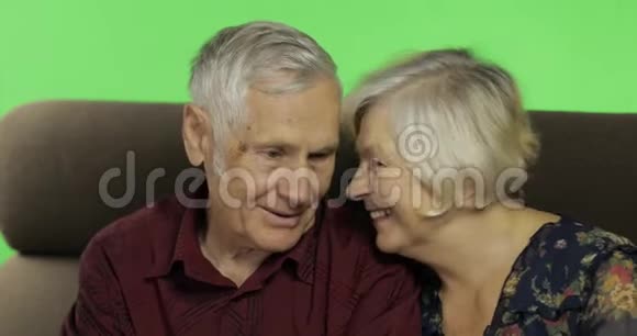 年长的男人和女人坐在沙发上微笑铬键视频的预览图