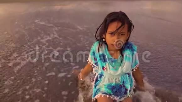 慢动作美丽快乐的亚洲印度尼西亚女孩无忧无虑地在海滩上玩在海里玩海浪视频的预览图