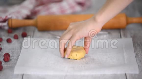 女人在烤纸上擀面团做蛋糕视频的预览图