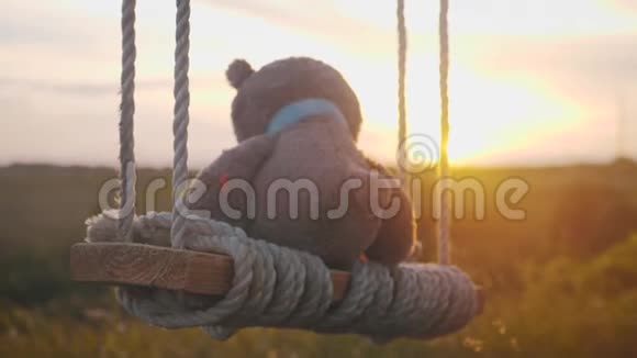 日落时泰迪熊坐在绳子上摆动关于孤独的概念视频的预览图