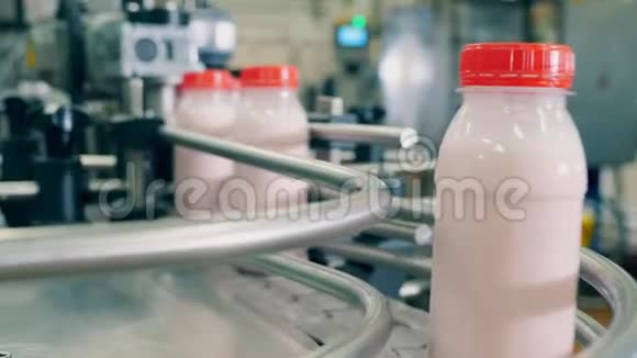 工厂生产线上的白色酸奶瓶生产和包装食品和饮料的自动化设备视频的预览图