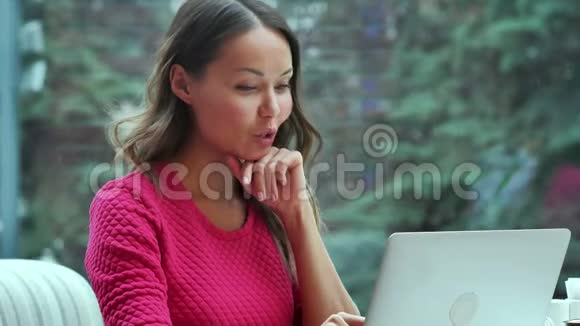 快乐的金发女人用笔记本电脑在咖啡馆里开视频会议视频的预览图