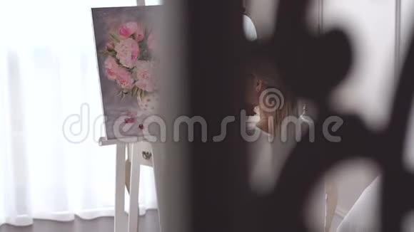 一位才华横溢的艺术家女孩在一幅花画前的肖像视频的预览图