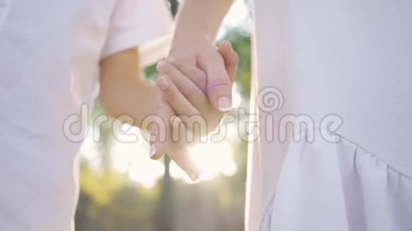 站在公园或森林里的女人和小男孩的特写家庭幸福一个家长手握双手视频的预览图
