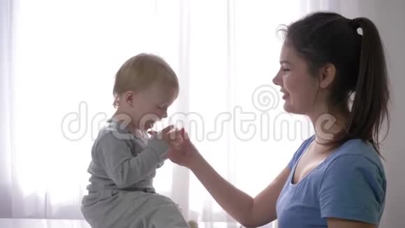 年轻的妈妈给小儿子一杯矿泉水解渴宝宝很开心笑得很近视频的预览图