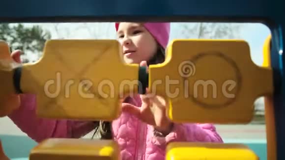 快乐的小女孩在凉爽的天气里在操场上玩耍孩子解决一个逻辑练习可爱的女孩喜欢视频的预览图