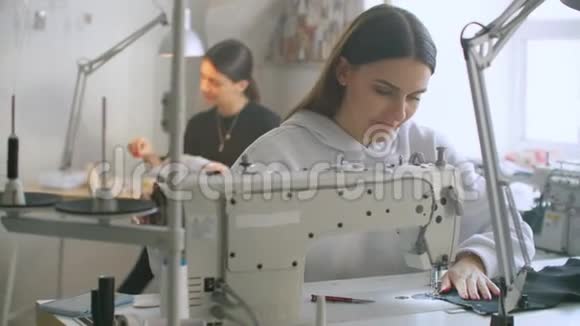 女时装设计师在车间用缝纫机工作的前景视频的预览图
