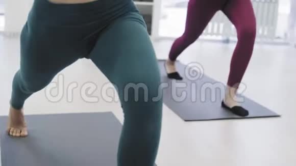 妇女团体在白色工作室练习瑜伽视频的预览图