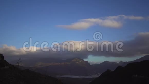 美丽的时间推移是一座高山山谷上有快速移动的云风景优美的全景山视频的预览图