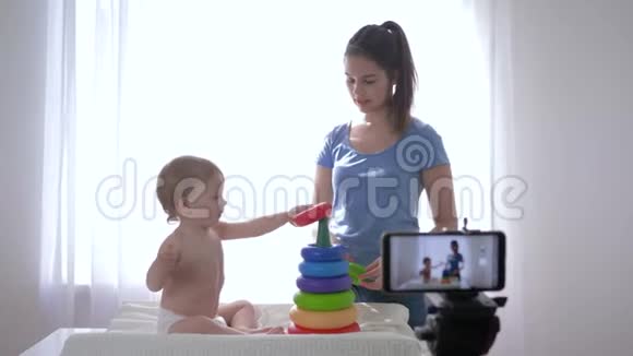 现代市场营销快乐的孩子与妈妈的vlogger玩的教育玩具同时录制在线视频博客为视频的预览图