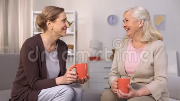 老年女性朋友在舒适的客厅里喝茶聊天视频的预览图
