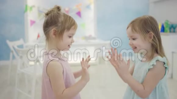两个小女孩站在镜头前玩拍手视频的预览图