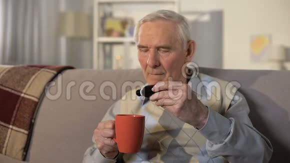 老年男性将医疗液滴入水杯医疗保健治疗视频的预览图