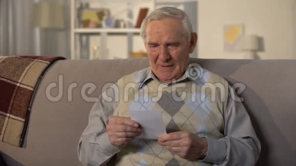 哭泣的老人看着照片回忆失去的老朋友回忆视频的预览图