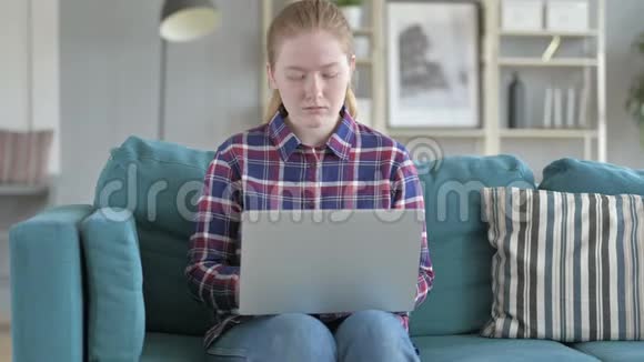 年轻女子手提电脑打喷嚏视频的预览图