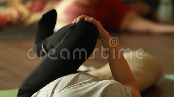 女人臀肌伸展瑜伽躺在垫子上视频的预览图