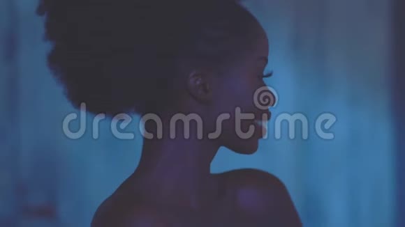 性感漂亮的美国黑人模特微笑着摆着蓝色的背景视频的预览图