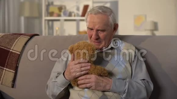 哭泣的老人拥抱泰迪熊失去孙子家庭支持视频的预览图