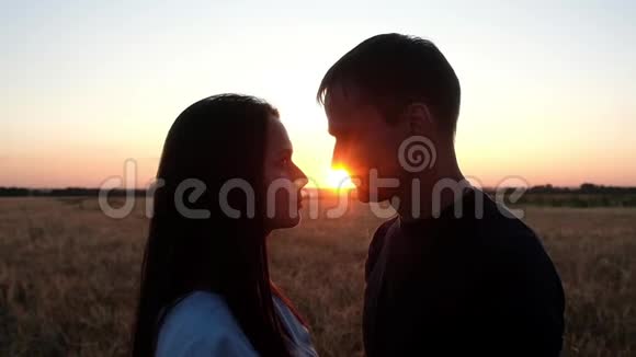 一对年轻夫妇在夏天日落的背景下接吻视频的预览图
