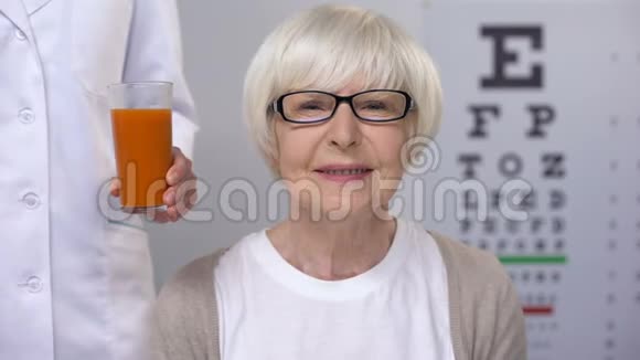 为快乐的老年女士提供新鲜胡萝卜汁保持良好的视力视频的预览图