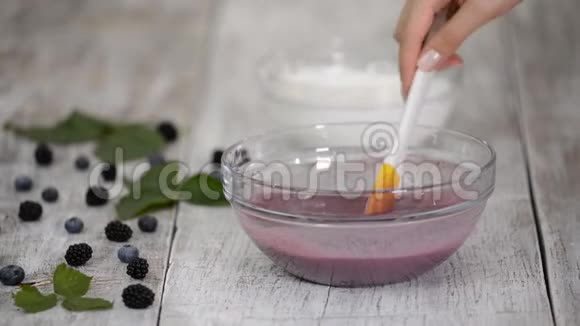 女糕点厨师正在厨房里混合浆果慕斯视频的预览图