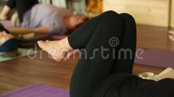 躺着的女人膝盖折叠旋转瑜伽视频的预览图