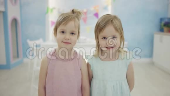两个可爱的小女孩站在镜头前摆姿势视频的预览图