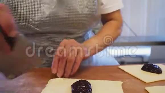 在商店的特写中女人在木桌上用果酱做馅饼视频的预览图