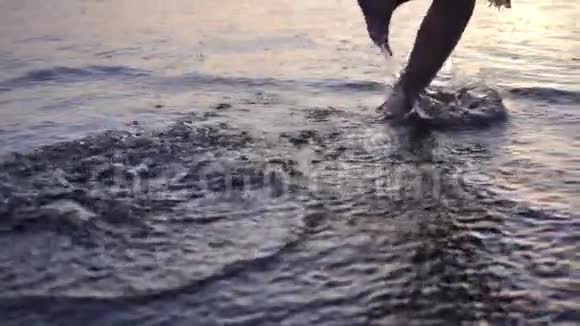 一个美丽的女孩沿着海洋海岸线奔跑的剪影视频的预览图
