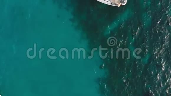 帆船在绿松石的海水上附近的度假者游泳空中无人机射击视频的预览图