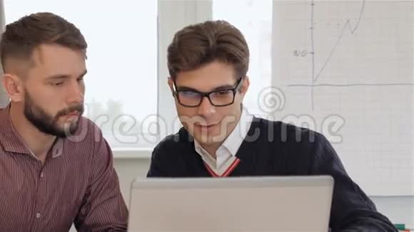 四位年轻的创意经理看着办公室里的笔记本电脑视频的预览图