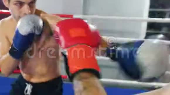 室内拳击训练两名男子在拳击场上进行激烈的战斗并保护视频的预览图