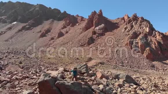 徒步旅行者带着背包在高山上旅行视频的预览图