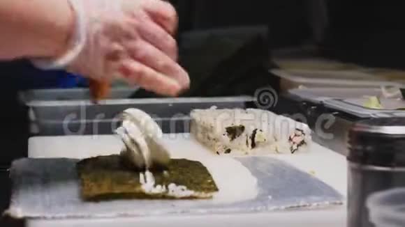 厨师在现代咖啡馆厨房的特写中烹制美味的寿司视频的预览图