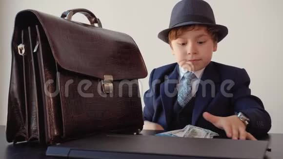年轻的小商人手里拿着美国的钞票在商业办公室里快乐男孩用现金举起双手视频的预览图