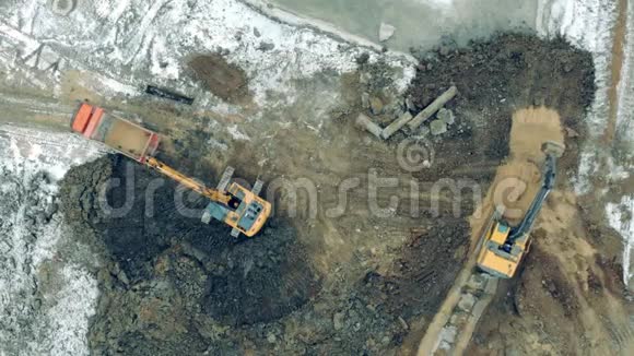 在采石场用沙子和石头工作的工业拖拉机从建筑工地上方的鸟瞰图视频的预览图