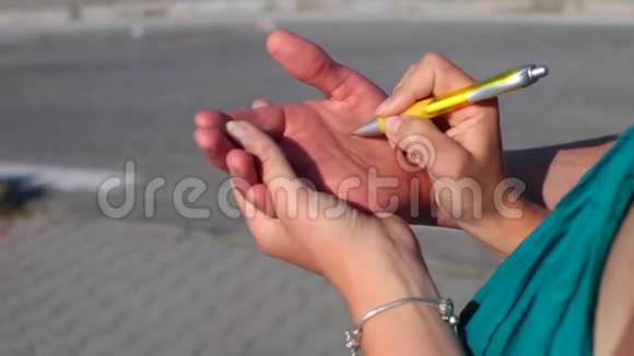 女孩用钢笔在男孩手上写字视频的预览图