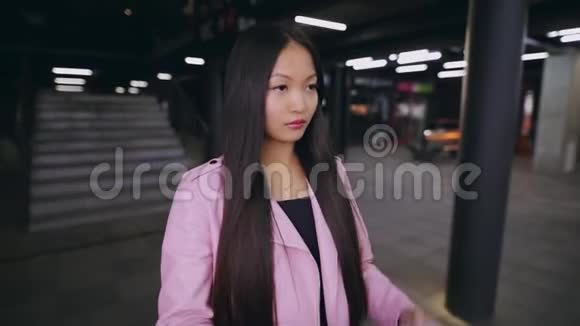 亚洲女人晚上戴着耳机在地下行走视频的预览图