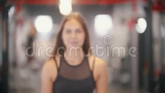 一个运动员微笑的女人在健身房拉一个哑铃视频的预览图