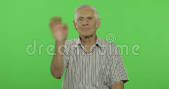 老人向照相机挥手性感钥匙背景上英俊的老人视频的预览图