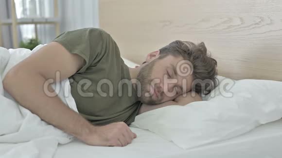 睡在床上时脖子疼的疲惫的年轻人视频的预览图