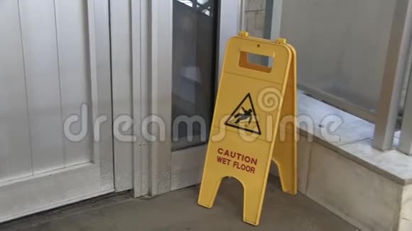 显示湿地板警告图标的标志站在混凝土表面的黄色招牌展览厅警告通告视频的预览图