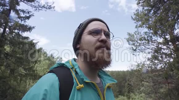 靠近徒步旅行者的人看着一边然后经过森林里的相机股票一个长胡子的人视频的预览图