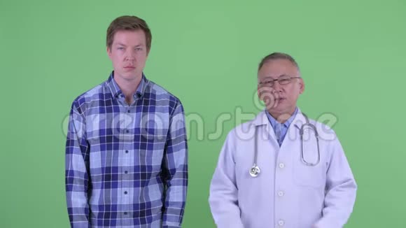 一个成熟的日本男医生和一个年轻人一起解释视频的预览图