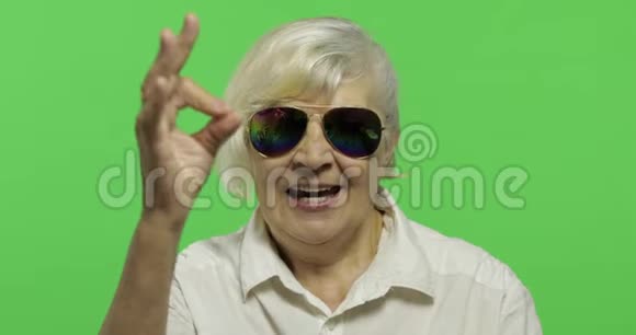 一位戴墨镜的老妇人表现出良好的姿态和微笑铬键视频的预览图