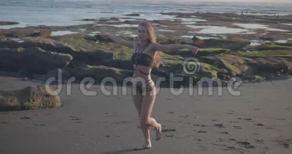 日落时穿比基尼在海滩上跳舞的美女视频的预览图