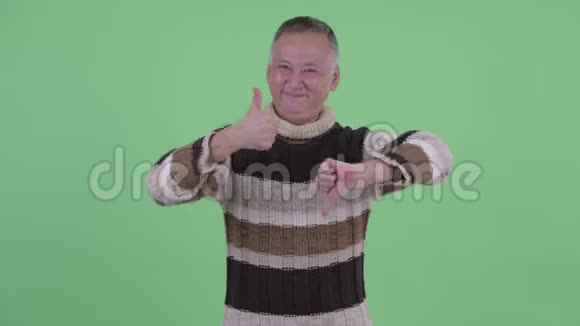 快乐迷茫成熟的日本男人在竖起大拇指和竖起大拇指之间选择视频的预览图